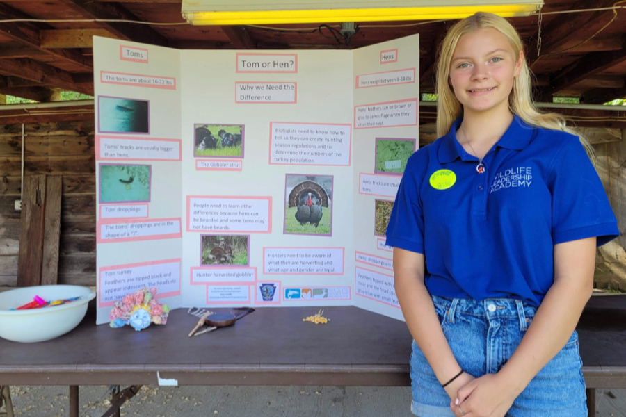 Skylar standing beside her trifold presentation.