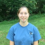 Girl in a blue shirt smiling at the camera