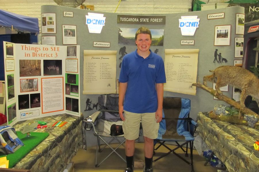 Kaden standing with his educational display.